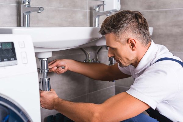 adult-plumber-fixing-sink-at-bathroom-resize.jpg